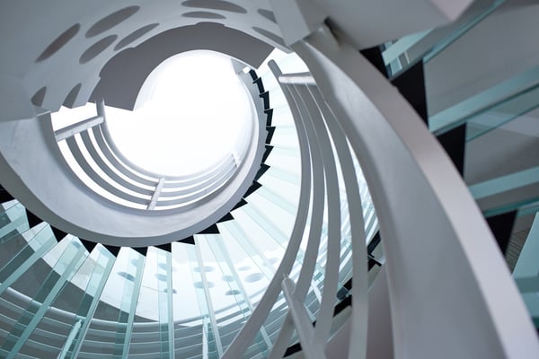 modern glass spiral staircase with metallic hand-rails.